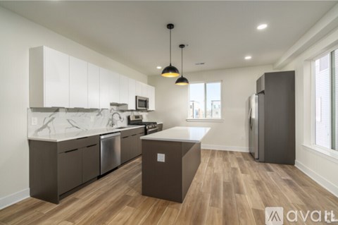 A modern kitchen with wooden floors and a large island.