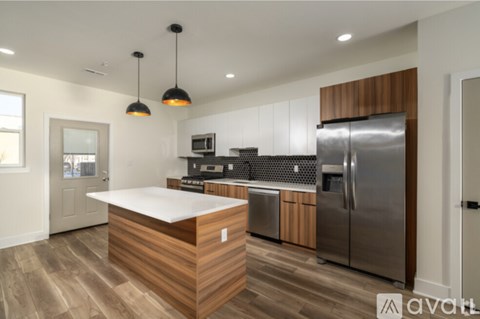 A modern kitchen with a wooden island and stainless steel appliances.