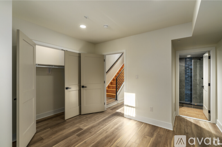 A spacious room with a staircase leading to the upper floor.