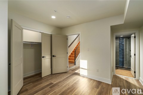 A spacious room with a staircase leading to the upper floor.