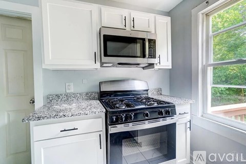 A kitchen with a stove top oven and microwave above it.