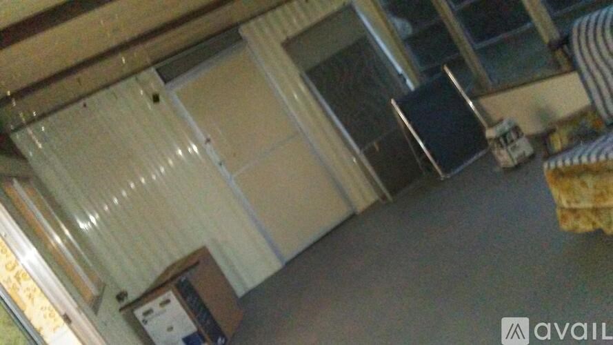 A room with a striped chair and a window with blinds.