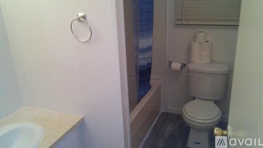 A bathroom with a toilet, sink, and a towel rack.
