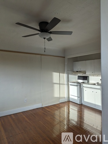 A room with a ceiling fan and wooden floors.
