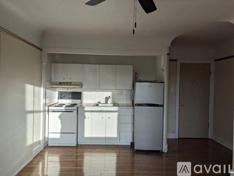 A kitchen with white appliances and cabinets is available for rent.