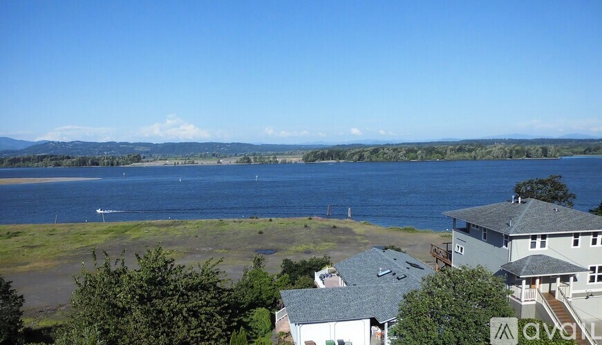 A view of a lake with houses and trees in the foreground.