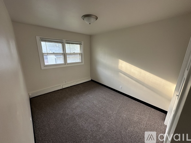 A room with a window and carpeted floor.