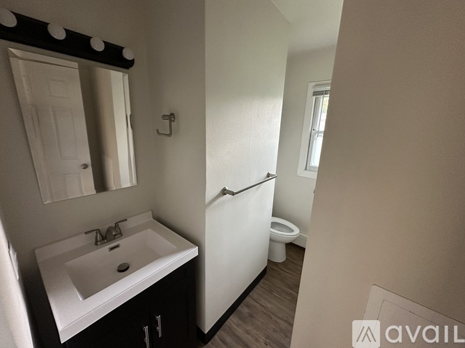 A bathroom with a sink, mirror, and toilet.