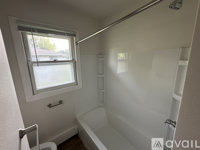A small bathroom with a window and a bathtub.