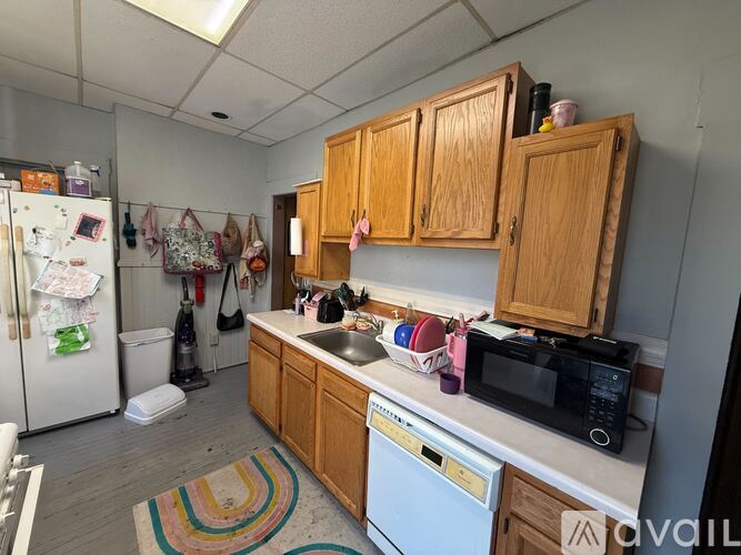 A kitchen with wooden cabinets and a white fridge.