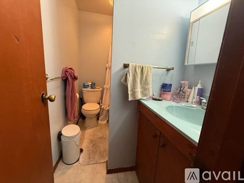 A bathroom with a toilet, sink, and towels.
