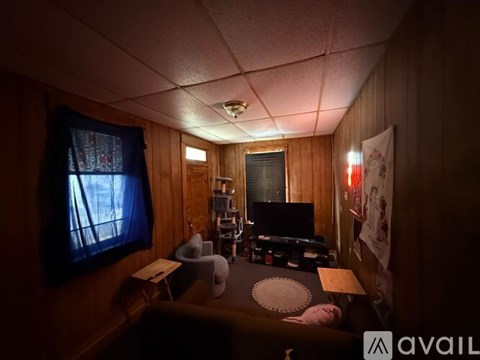 A room with a desk, chair, and a window with curtains.