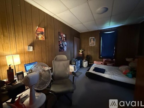 A room with a bed, desk, and chair.