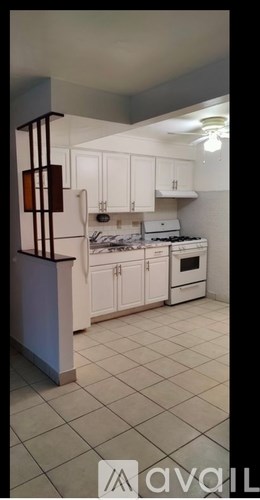 A kitchen with white cabinets and a stove top oven.