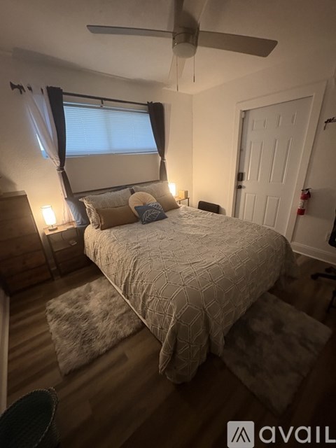 A bedroom with a bed, a ceiling fan, and a rug.