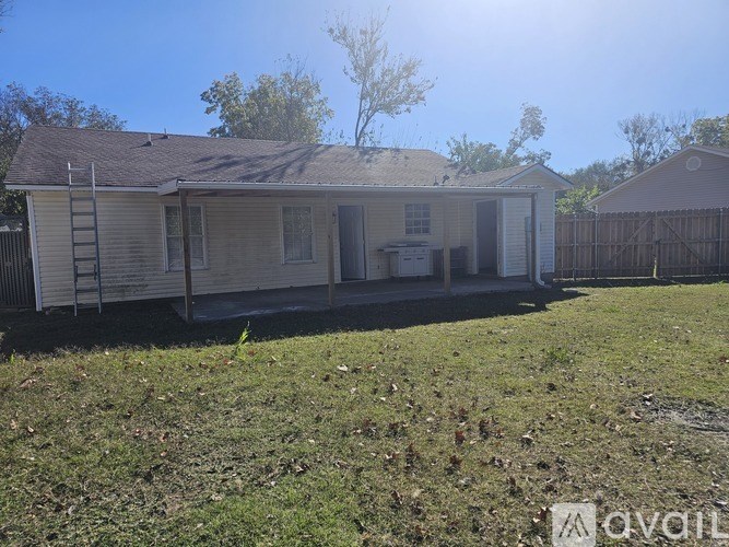 A house with a brown roof and a white fence is for sale.