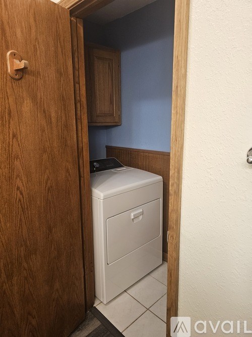 A white filing cabinet is in a wooden doorway.