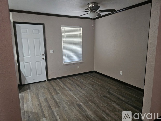 A room with a ceiling fan and a door.