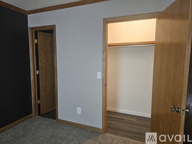 A room with a carpeted floor and a door on the left.
