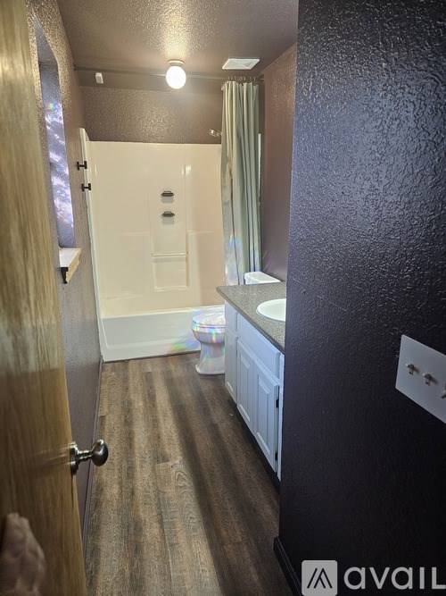 A bathroom with a toilet, sink, and shower.