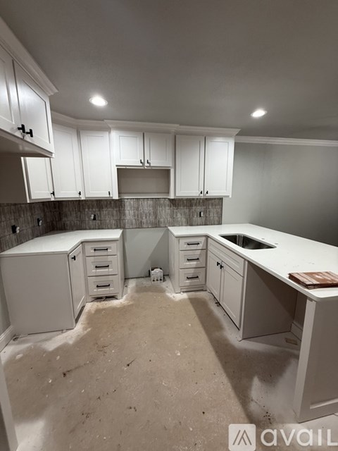 A kitchen with white cabinets and a countertop is under construction.