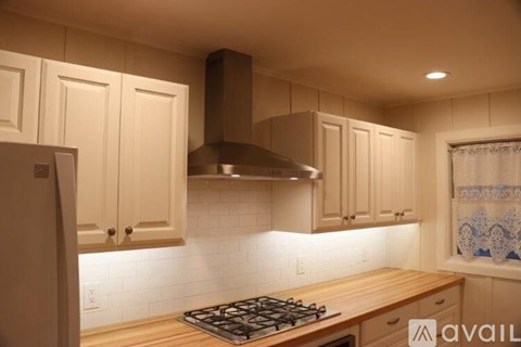 A kitchen with wooden cabinets and a stainless steel range hood.
