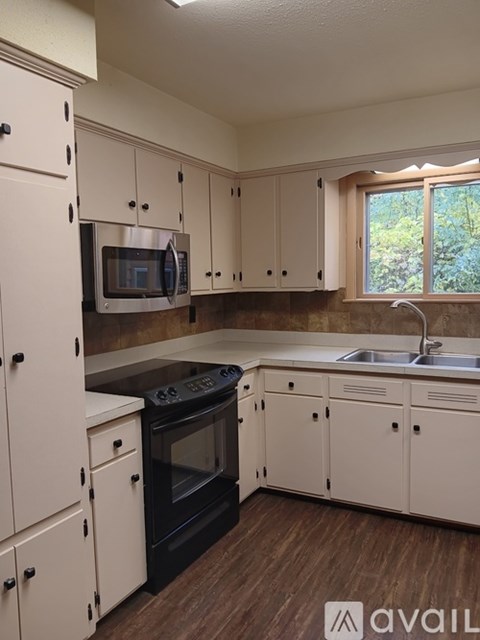A kitchen with white cabinets and a black oven.
