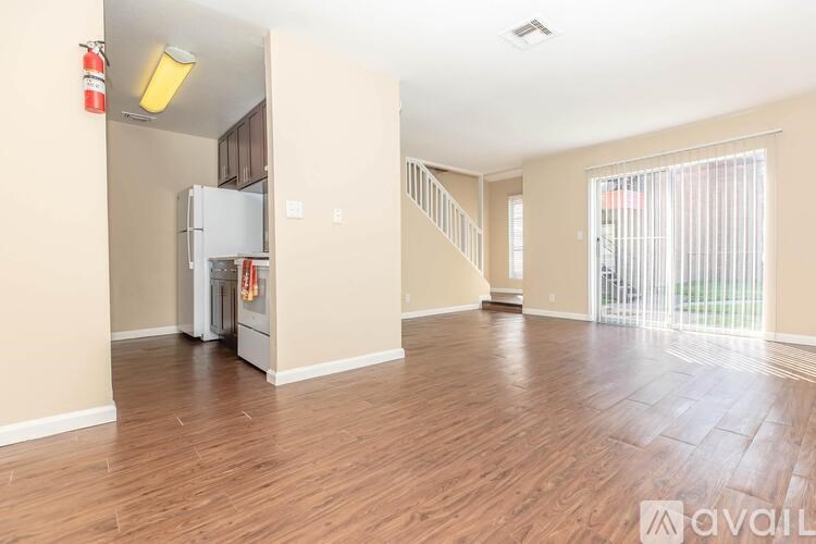 A spacious living room with hardwood floors and a staircase leading to another room.