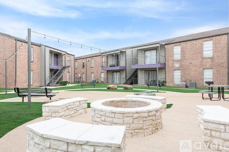 A courtyard with a fire pit surrounded by brick buildings.