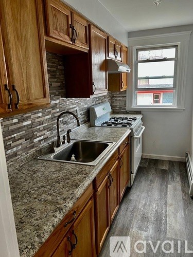A kitchen with wooden cabinets and granite countertops.