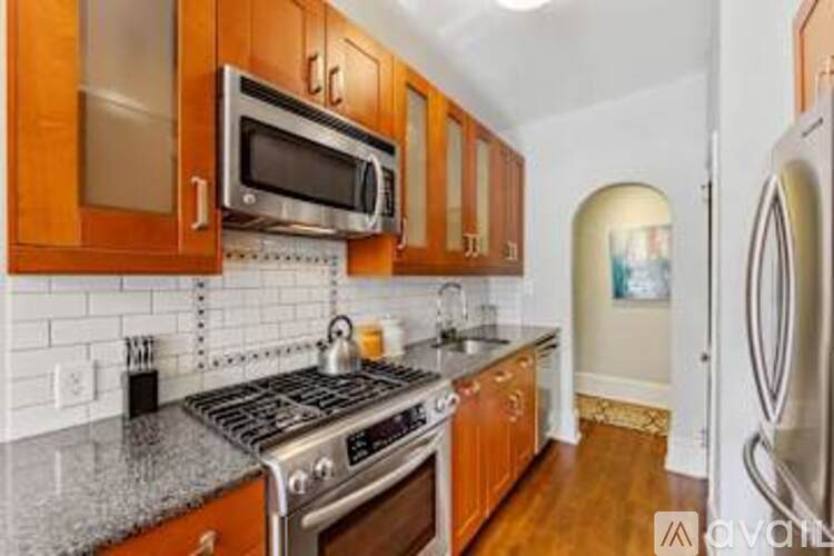 A kitchen with wooden cabinets and a stainless steel stove top.