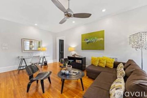 A living room with a brown couch, a coffee table, and a painting on the wall.