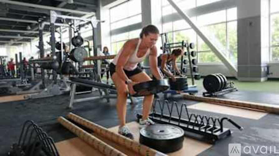 A man is working out in a gym with a barbell.