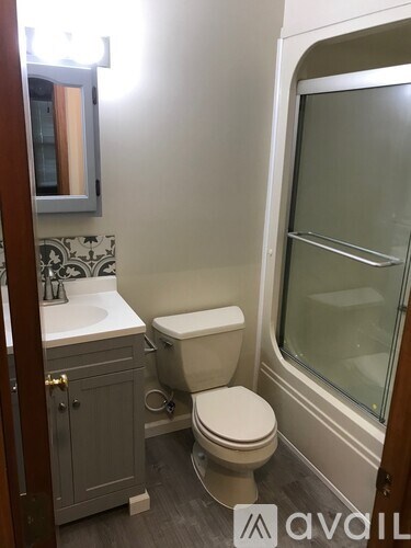 A bathroom with a toilet, sink, and shower.