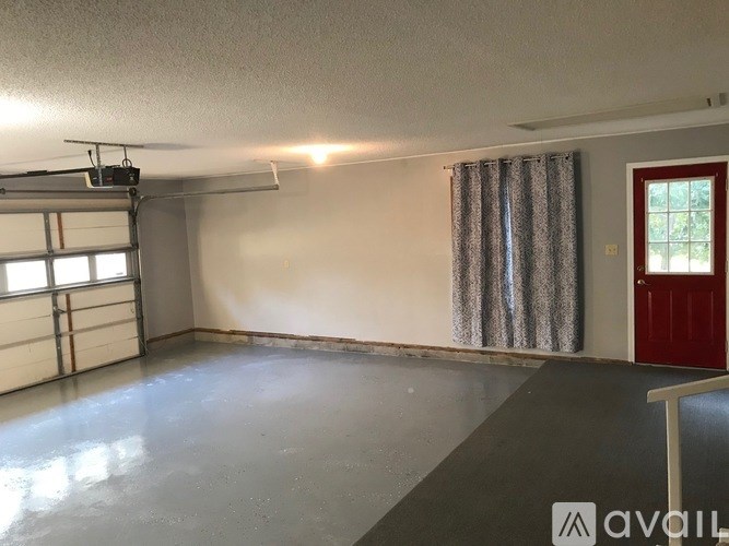 A room with a red door and a garage door opener on the wall.
