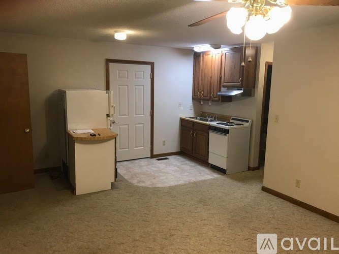 A kitchen area with a refrigerator, sink, and cabinets.