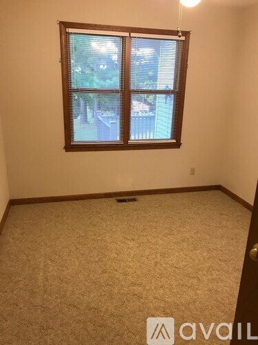 A room with a carpeted floor and a window.