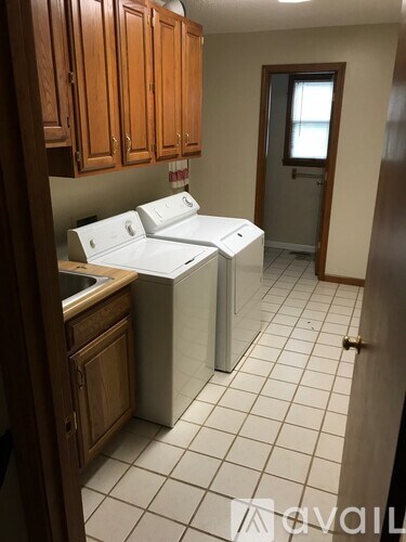 A kitchen with white appliances and wooden cabinets.