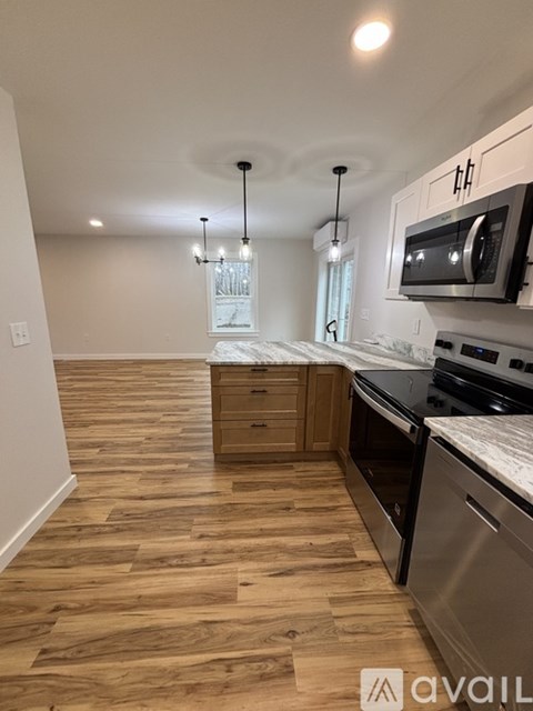 A kitchen with wooden floors and stainless steel appliances.