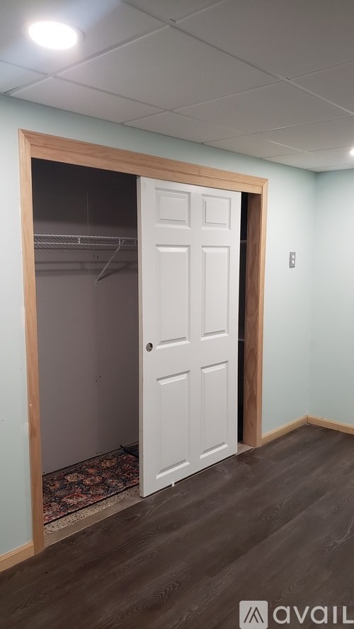 A room with a white door and a rug on the floor.