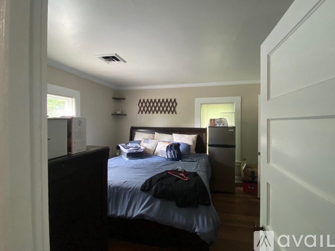 A bedroom with a bed, dresser, and a window.