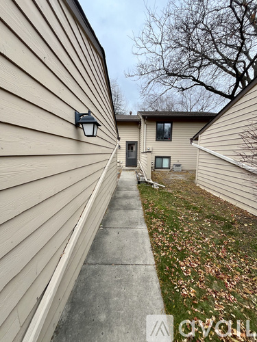 A house with a beige siding and a black lamp on the wall.