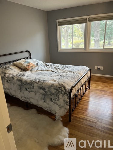 A bedroom with a marble bed and a white furry rug.