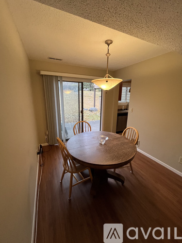 A dining room with a round wooden table and chairs.