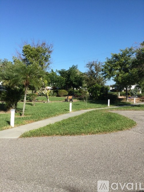 A park with a gravel path and green grass.