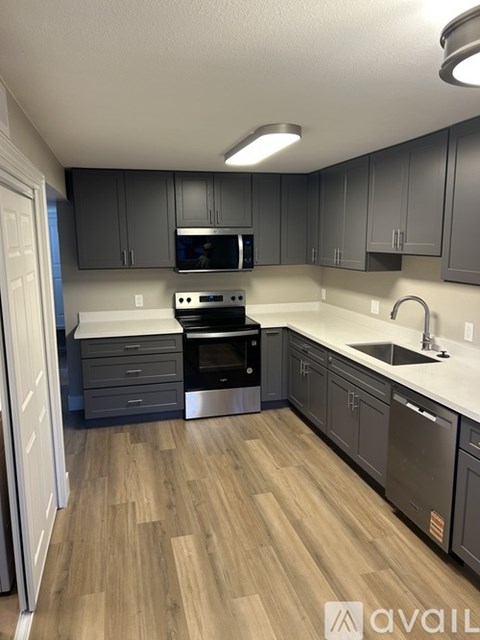 A kitchen with a stove top oven and microwave built into the cabinetry.