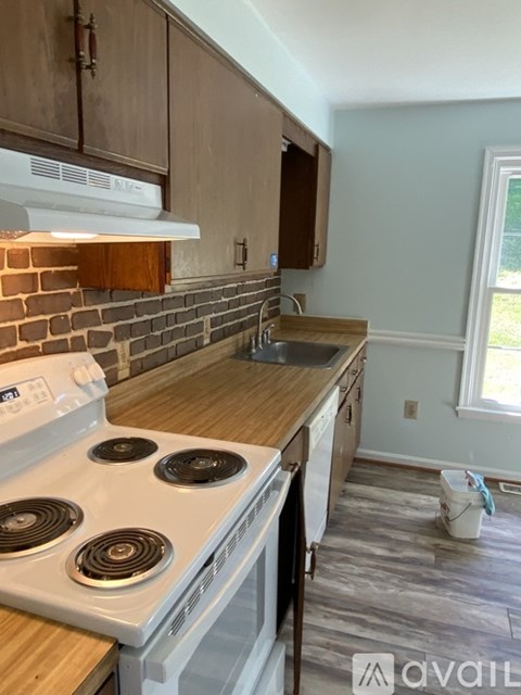 A kitchen with a white stove and wooden cabinets.