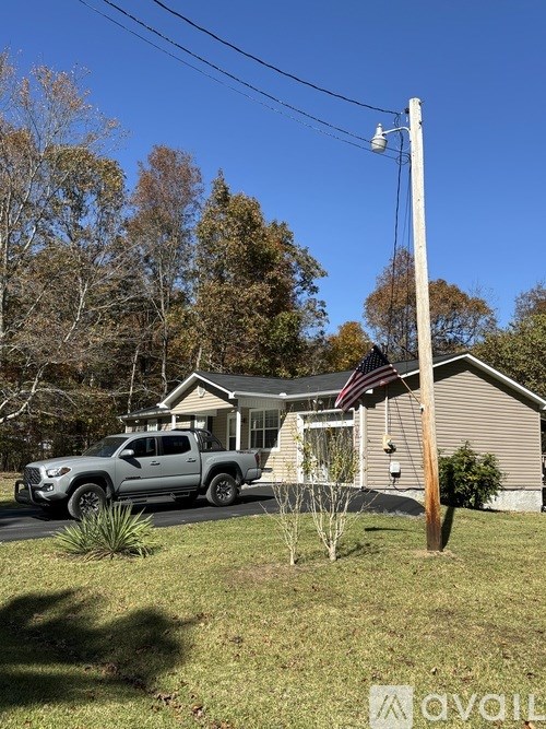 A house with a grey truck parked in front.