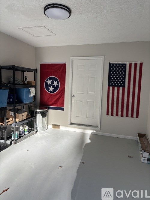 A room with a Tennessee flag and an American flag hanging on the wall.