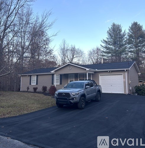 A silver truck is parked in front of a house.